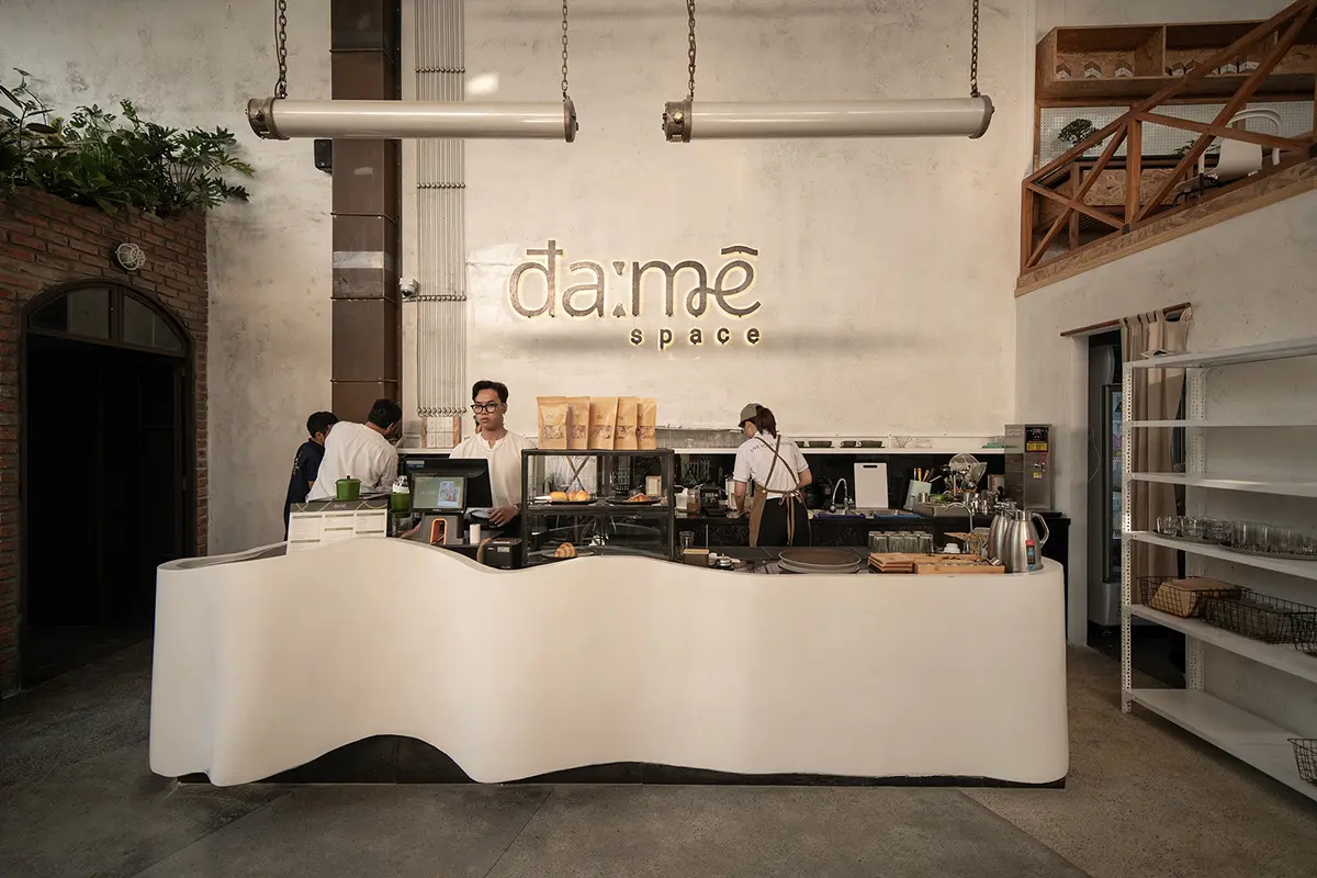 Không gian quán cafe phong cách industrial với tường gạch thô và nội thất kim loại.
